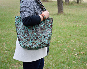 Dress up your outfit with a beautiful Tanned Cowhide/Stamped Leather Tote